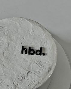 a white cake with the word bdn spelled in black icing on top