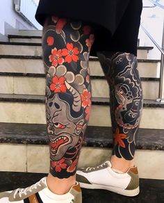 a man with tattoos on his legs and leggings is standing in front of some stairs