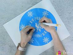 someone using scissors to cut out a snowflake design