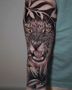 a man with a tattoo on his arm has a leopard and leaves design on it