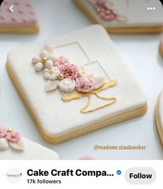 some decorated cookies sitting on top of a white table with pink and yellow flowers in the middle