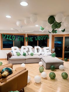 a living room filled with lots of furniture and balloons in the shape of letters that spell out bride