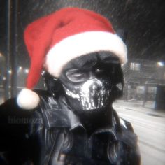 a man wearing a santa hat and black paint on his face is seen in this image