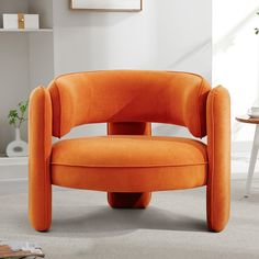 an orange chair sitting on top of a carpeted floor next to a white wall