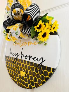 a bee themed welcome sign with sunflowers and ribbon attached to the front door