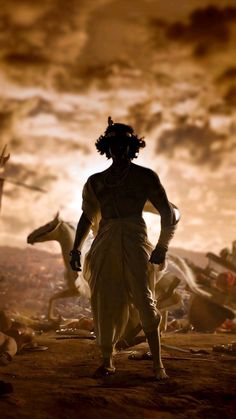 the silhouette of a man standing in front of a group of men with horses behind him