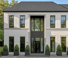 a large white brick house with black windows