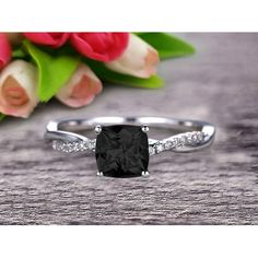 a black diamond ring sitting on top of a wooden table