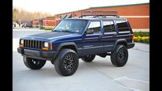 a blue jeep is parked in a parking lot