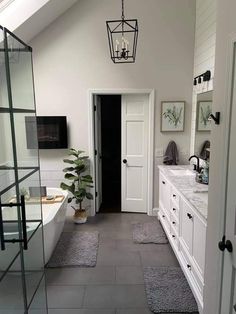 a bathroom with two sinks and a bathtub next to a doorway that leads into another room