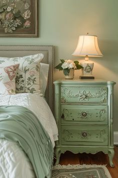 a bedroom with a bed, nightstand and lamp in the corner next to each other