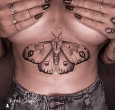 a woman's stomach with a butterfly tattoo on her belly and hands covering the chest