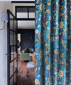 a living room with wood floors and blue curtains