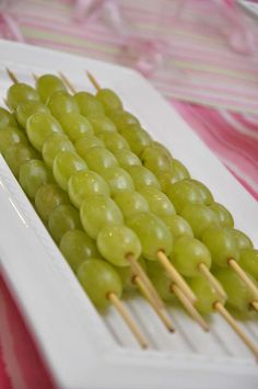 grapes are arranged on skewers with toothpicks in a white plate, ready to be eaten