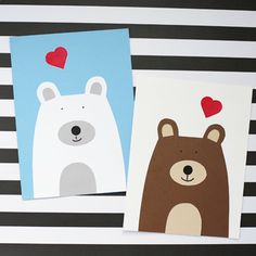 two cards with bears and hearts on them sitting next to each other in front of a black and white striped background