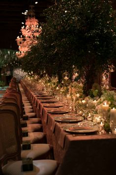 a long table is set up with candles and place settings for dinner guests to enjoy