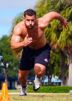 a shirtless man is running through an obstacle course