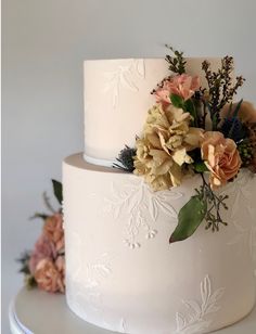 a white wedding cake with flowers on top