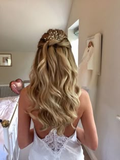 the back of a woman's head as she stands in front of a bed