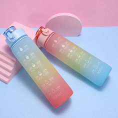 two plastic toothbrushes sitting next to each other on a blue and pink surface