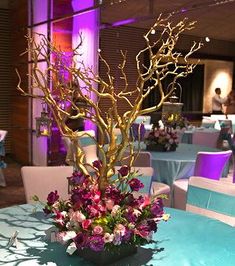 a vase filled with flowers sitting on top of a blue table covered in purple and white linens