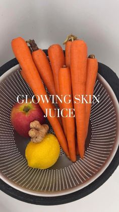 there are carrots, apples and lemon in the bowl on the table with the words glowing skin juice