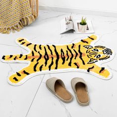 a pair of slippers sitting on top of a floor next to a tiger rug