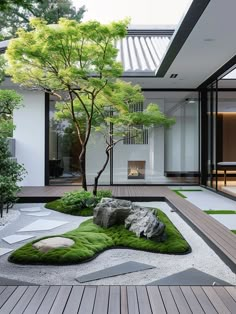 an outdoor area with grass and rocks in the foreground, surrounded by wooden decking