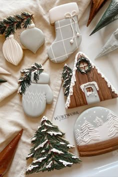 some cookies are laying on a table with decorations in the shape of houses and trees