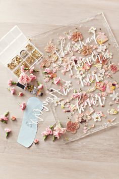 a glass tray filled with pink and white confetti on top of a wooden table