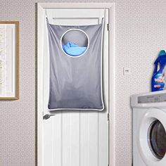 a laundry hamper hanging on the wall next to a washer and dryer