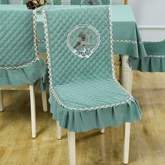 a dining room table and chairs covered in aqua blue covers with white trimmings