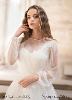 a woman in a wedding dress posing for the camera with her hand on her cheek