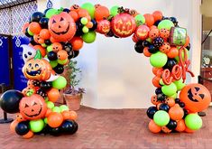 an arch made out of balloons and pumpkins