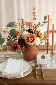 the table is set with flowers and candles