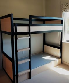 a bunk bed with no mattresses is in the corner of a room next to a window