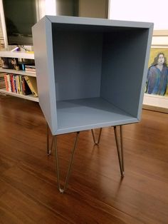 a blue shelf sitting on top of a hard wood floor next to a book case