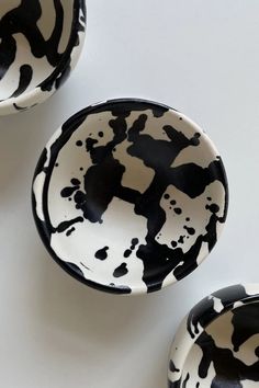 three black and white bowls sitting next to each other