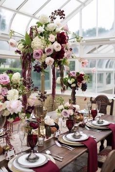 a dining room table set with flowers and place settings