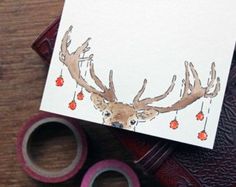 a card with an image of a deer's head on it next to some scissors