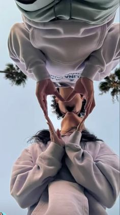 a woman is upside down in the air with her hands on her hips and head tilted to the ground