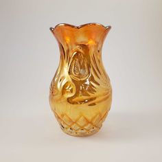 a yellow glass vase sitting on top of a white table