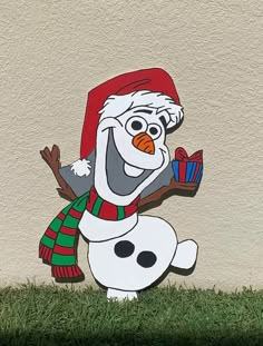 a snowman with a red hat and scarf holding a gift box in his hand