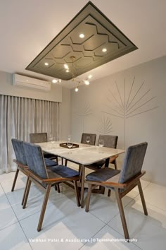 a dining room table with chairs and a ceiling fan in the middle of the room