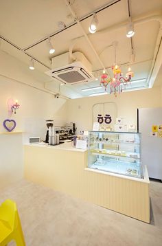 the interior of an ice cream shop with yellow chairs and chandeliers hanging from the ceiling