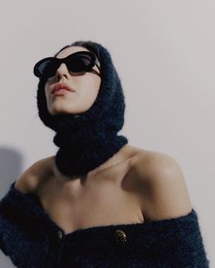 a woman wearing sunglasses and a black sweater