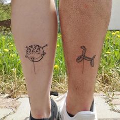 two people with tattoos on their legs standing next to each other in front of grass and flowers