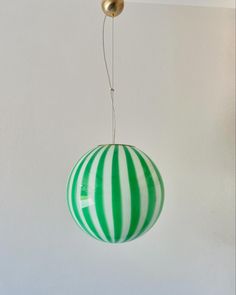 a green and white striped ball hanging from a ceiling