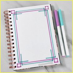 an open notebook with two pens next to it