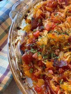 a casserole dish with meat and vegetables in it on a plaid table cloth